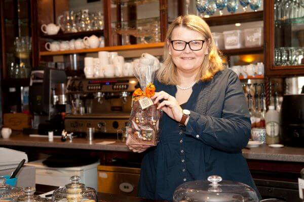 woman standing in front of a counter full of chocolate