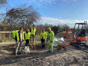 A photo of people working outside along a towpath wearing high visibility jackets