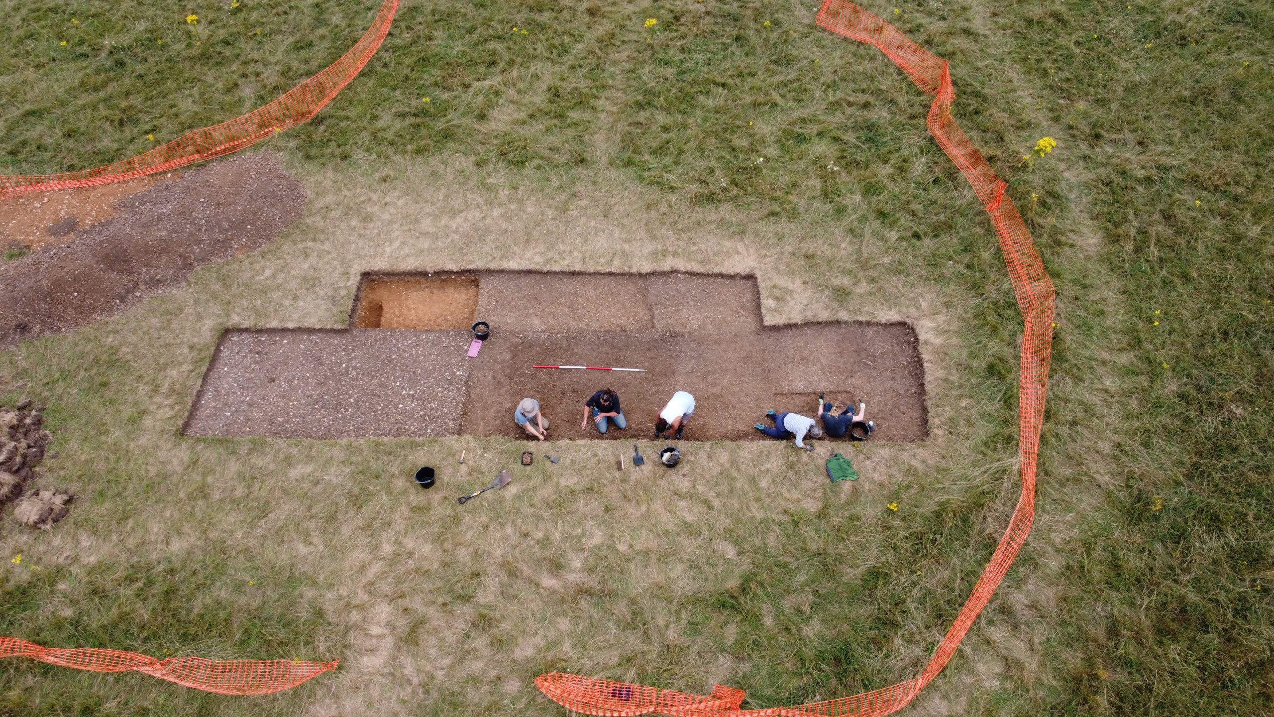 Aerial photo of people digging in a trench.