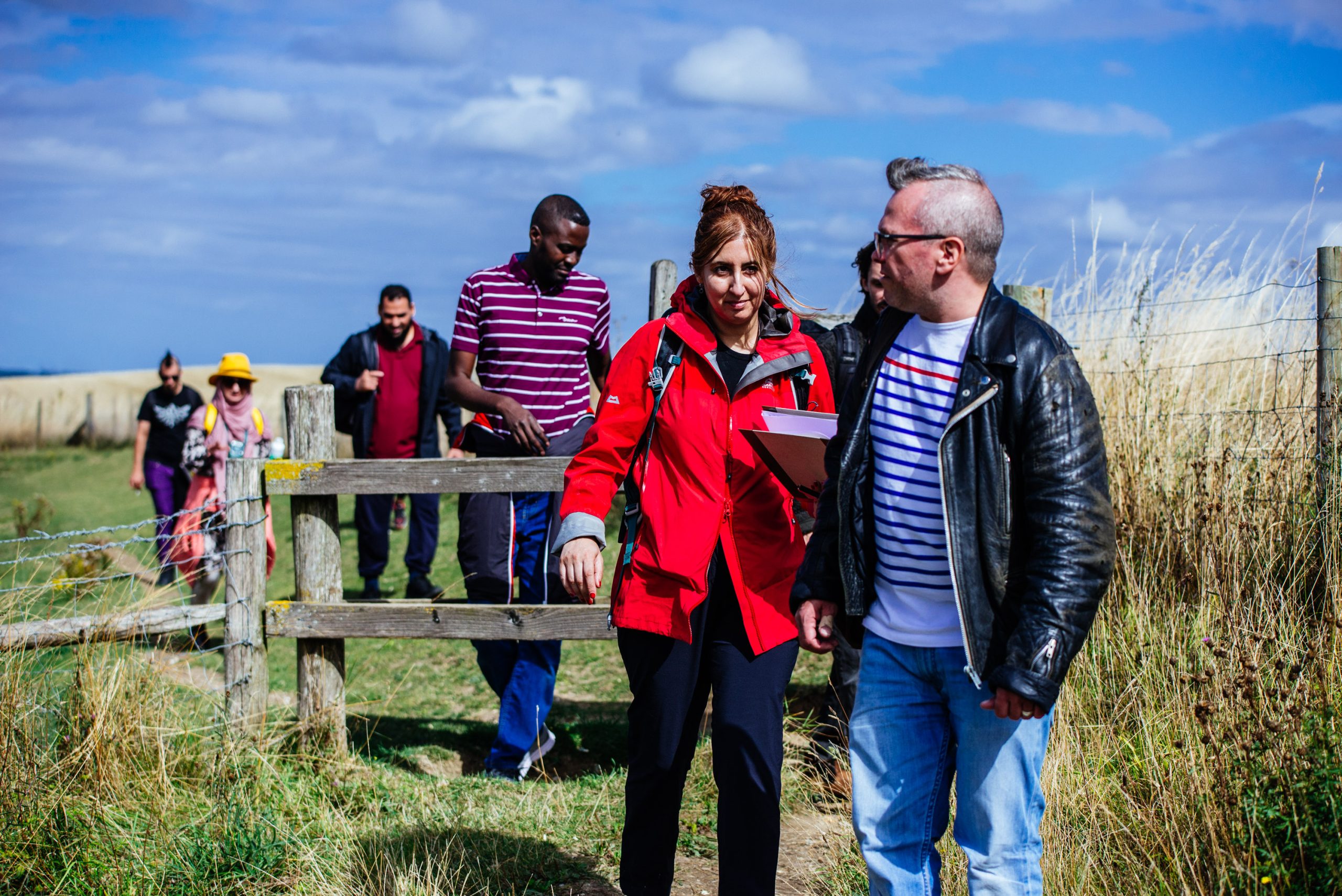 A group of people walking in the countryside on a sunny day.